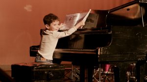 child at piano performing a song